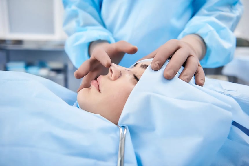 A surgeon examines a patients nose before alarplasty surgery in Singapore