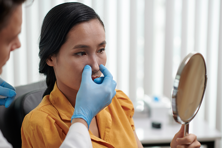 Plastic-surgeon-letting-patient-look-at-her-new-nose-after-rhinoplasty